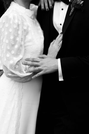 A series of black and white wedding photos showing a couple embracing in formal attire.