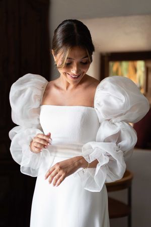 A wedding dress with dramatic puffy white sleeves and a fitted bodice creates an elegant silhouette.