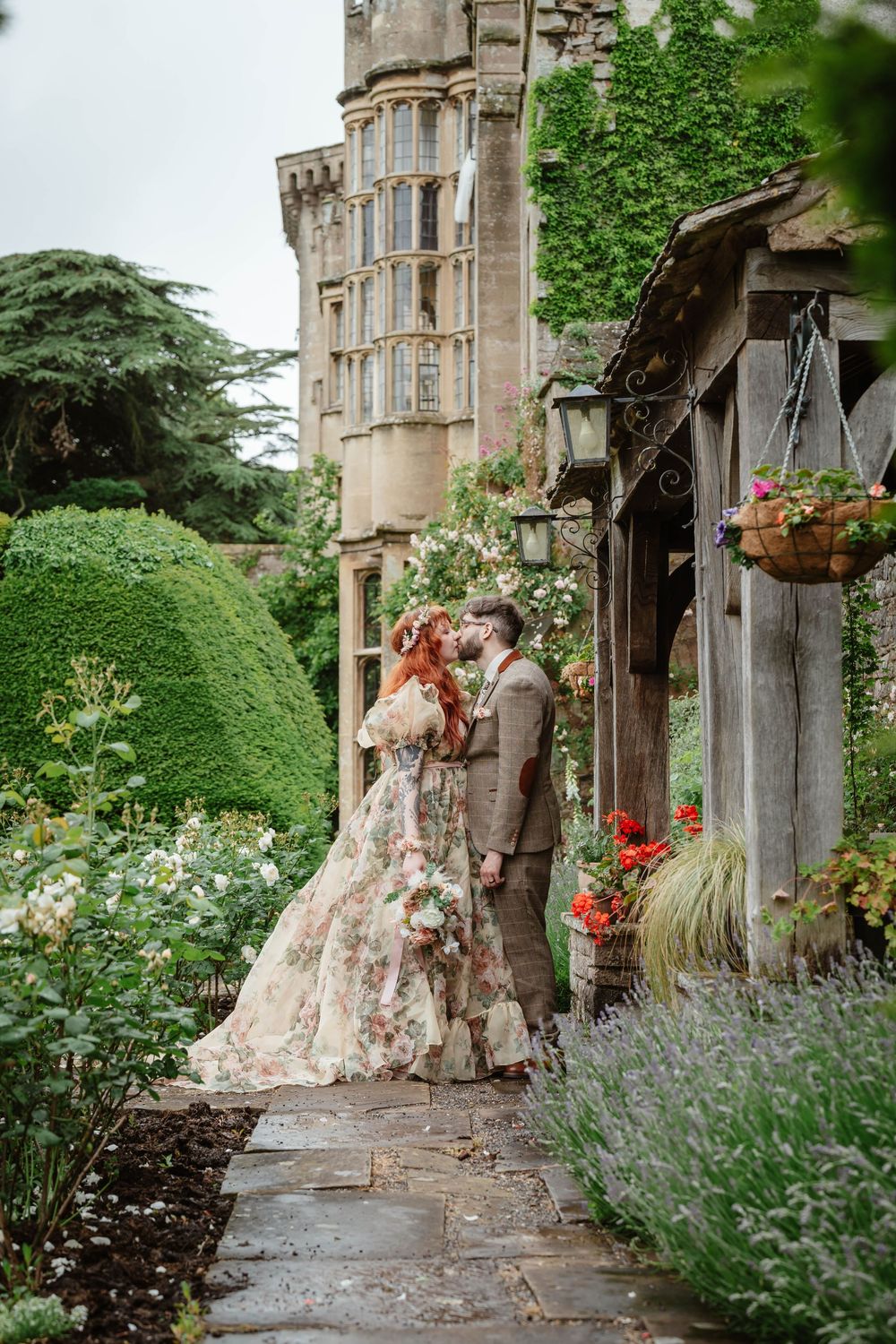 Bride and groom portraits at Thornbury Castle gloucestershire gardens with roses