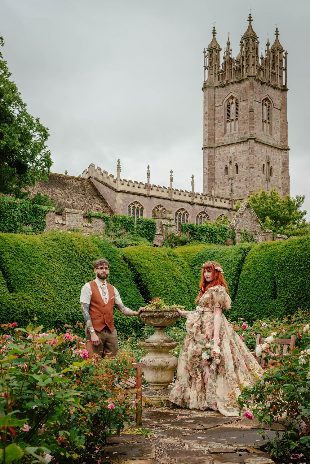 Bride and groom portraits at Thornbury Castle gloucestershire with church in background
