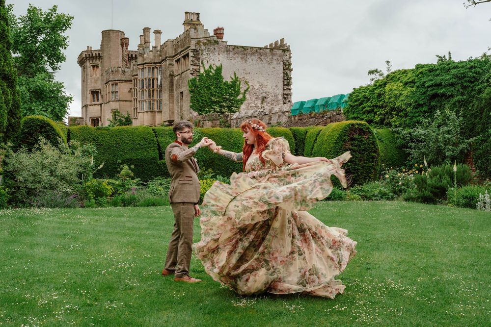 Bride and groom portraits at Thornbury Castle gloucestershire dancing on the garden lawn
