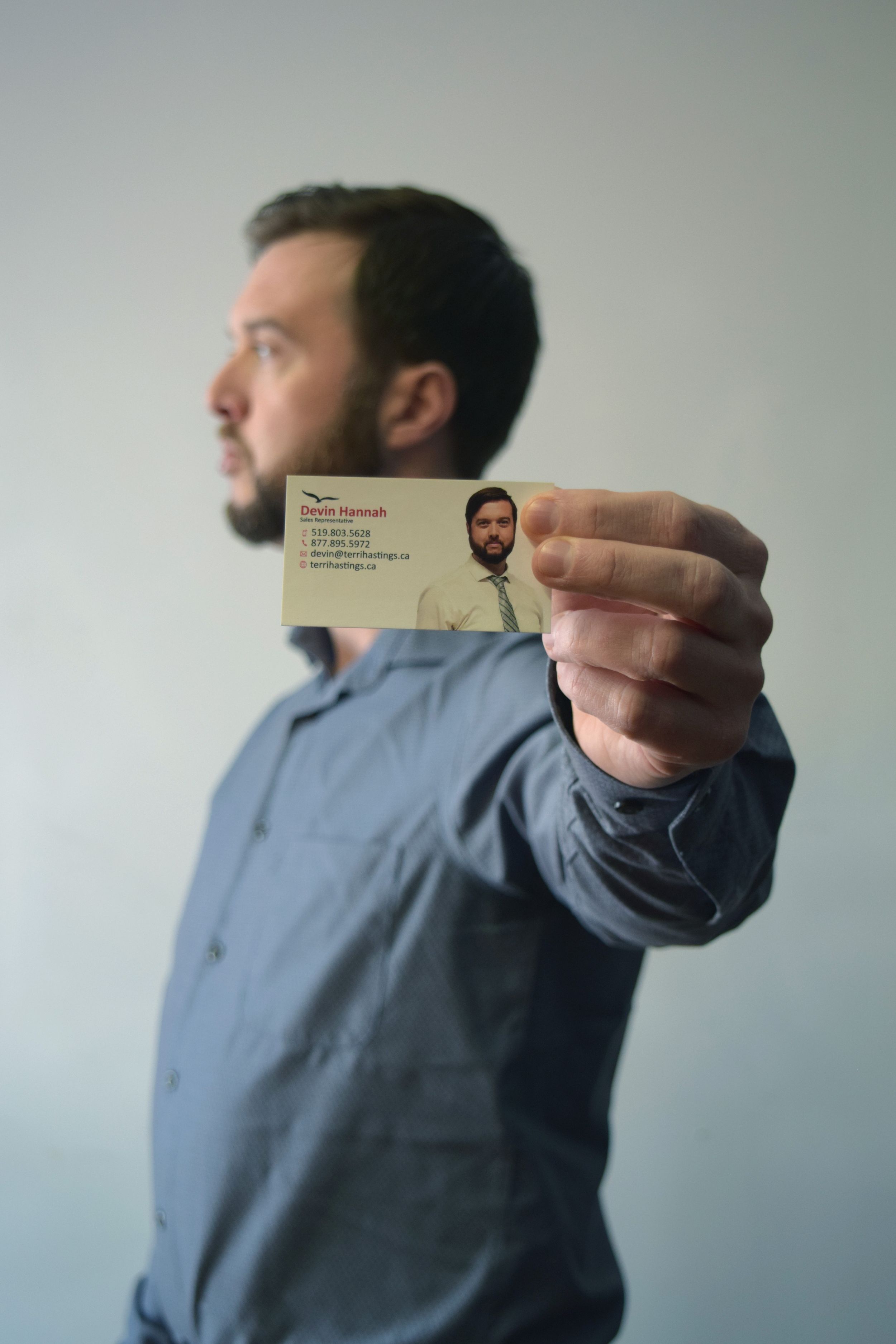 Series of shots showing someone holding up a business card against a light background.