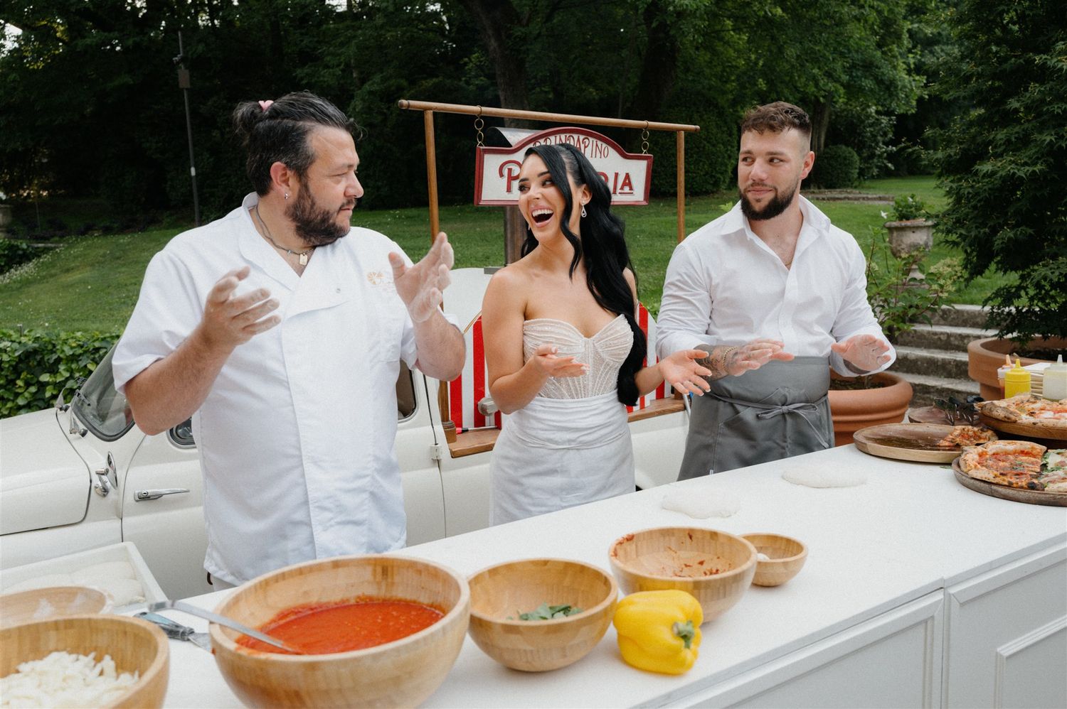 Bride and groom making pizza during their welcome party at a magnificent villa in the countryside near Borghetto