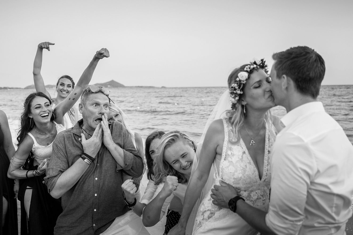 Brautpaar küsst sich am Strand, Freunde reagieren entsetzt: Lustiger, authentischer Hochzeitsmoment und pures Storytelling.