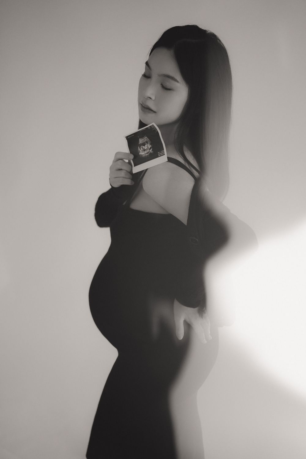 Artistic black and white portrait series showing silhouette poses against a light wall with dramatic shadows.一組藝術化的黑白肖像系列作品，展現了人物在淺色牆面前擺出的剪影