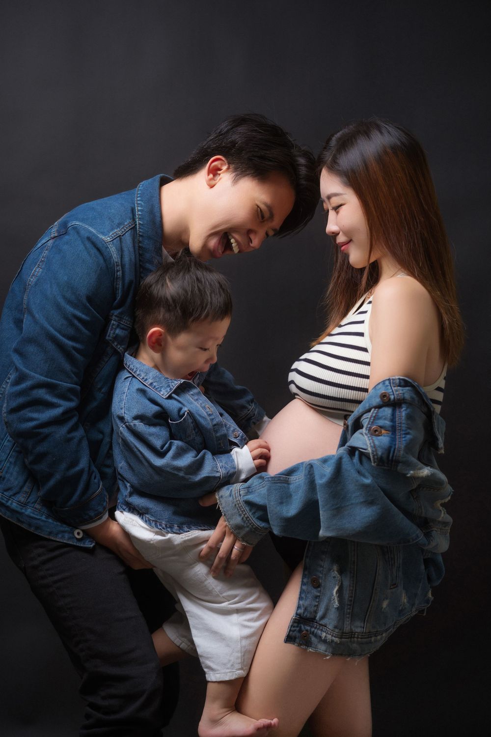A series of intimate black and white photographs showing a couple in denim jackets against a dark background.一組親密的黑白照片，照片中一對情侶身穿牛仔夾克，背景是深色的。