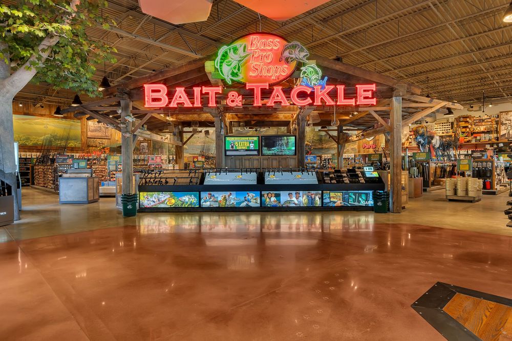 Bass Pro Shops Bait and Tackle department featuring a large neon sign and fishing displays.