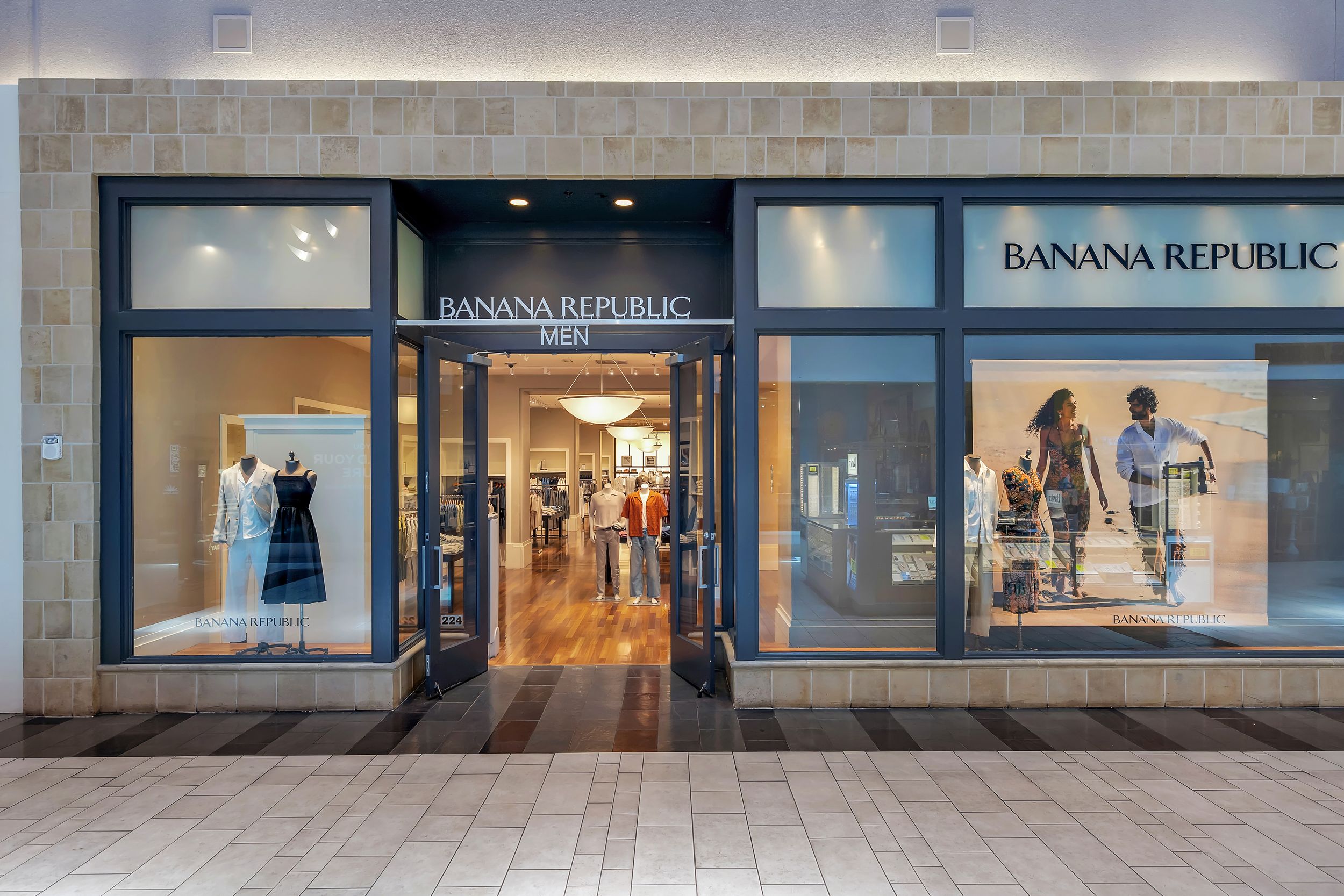 Banana Republic Men's store exterior with large display windows showcasing clothing at a modern shopping mall.