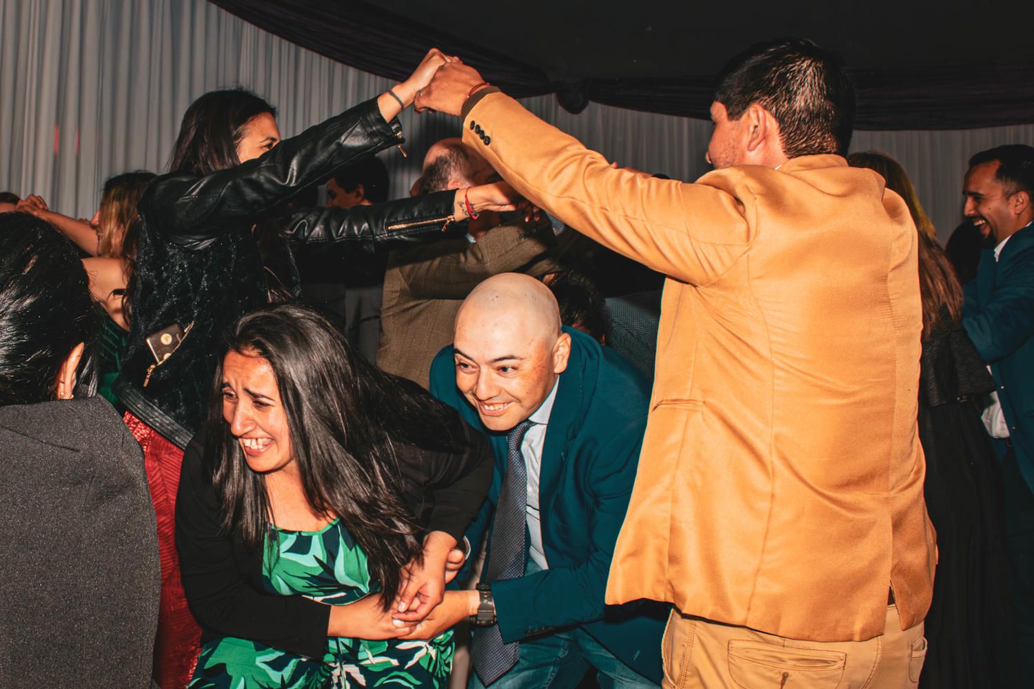Pista de baile de recepción de matrimonio con luces coloridas y invitados celebrando.