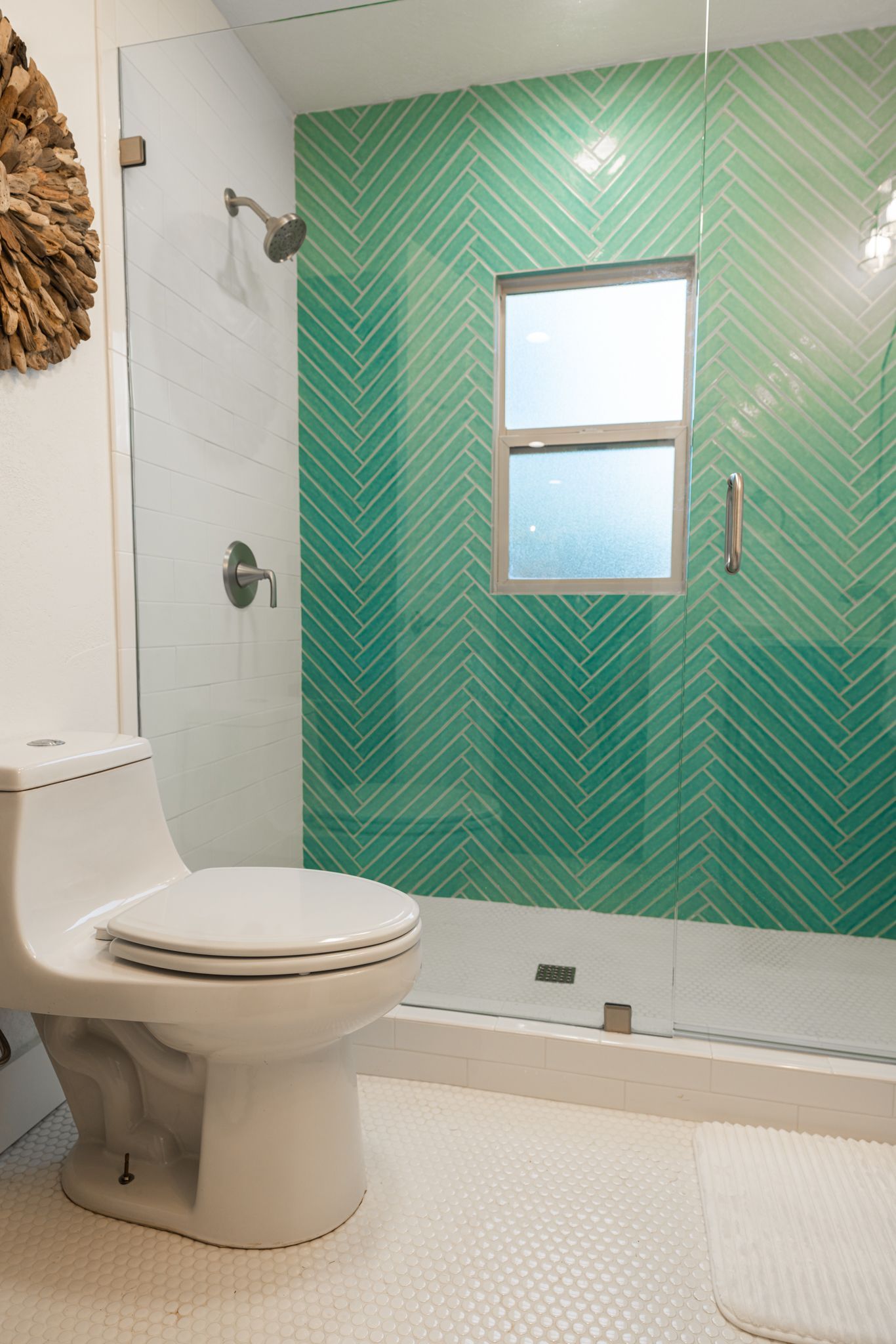 Modern bathroom featuring turquoise herringbone tile wall and white fixtures.