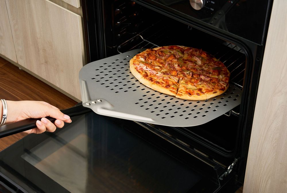 Ảnh chụp pizza peel lấy bánh pizza ra khỏi lò nướng