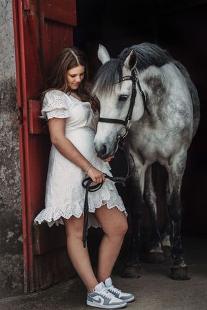 Unikke konfirmationsbilleder med hest i blødt, stemningsfuldt lys, der fremhæver både elegance og nærvær.