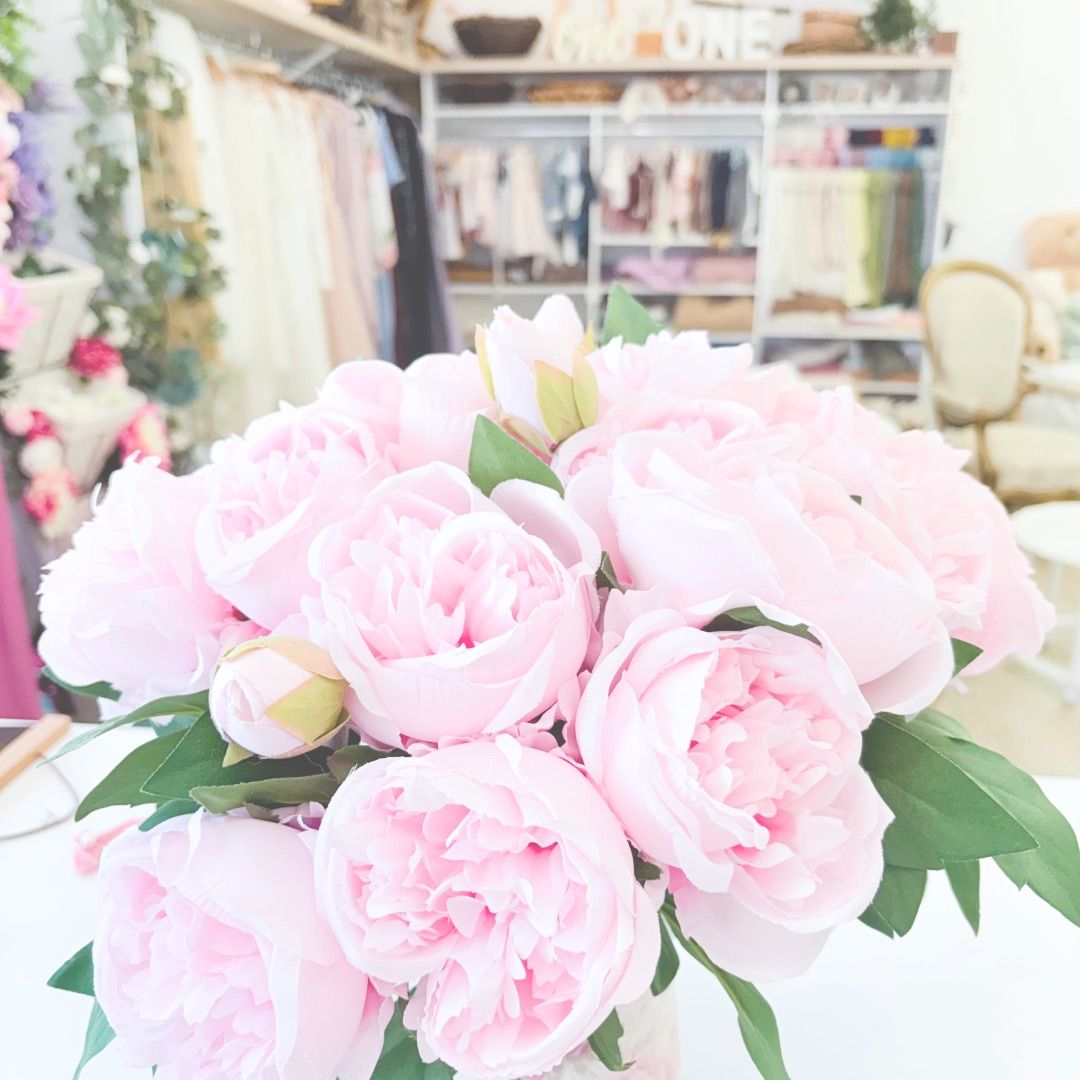 Delicate pink carnations with ruffled petals arranged in a repeating pattern against a light background.