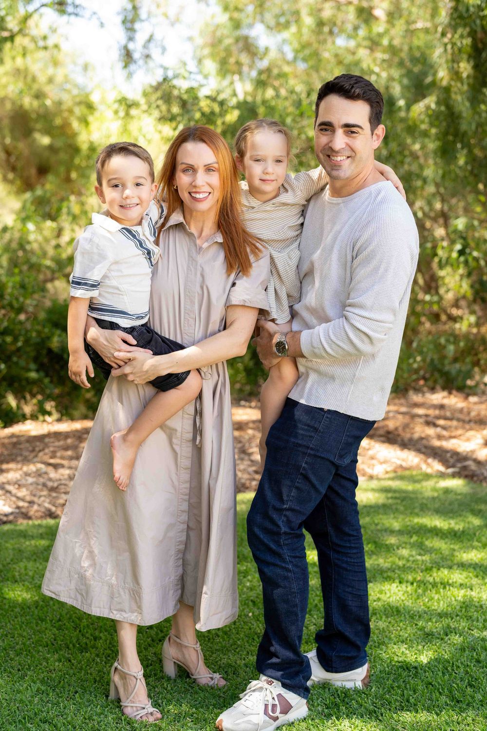 A family holding their children during an outdoor family photography session in Perth