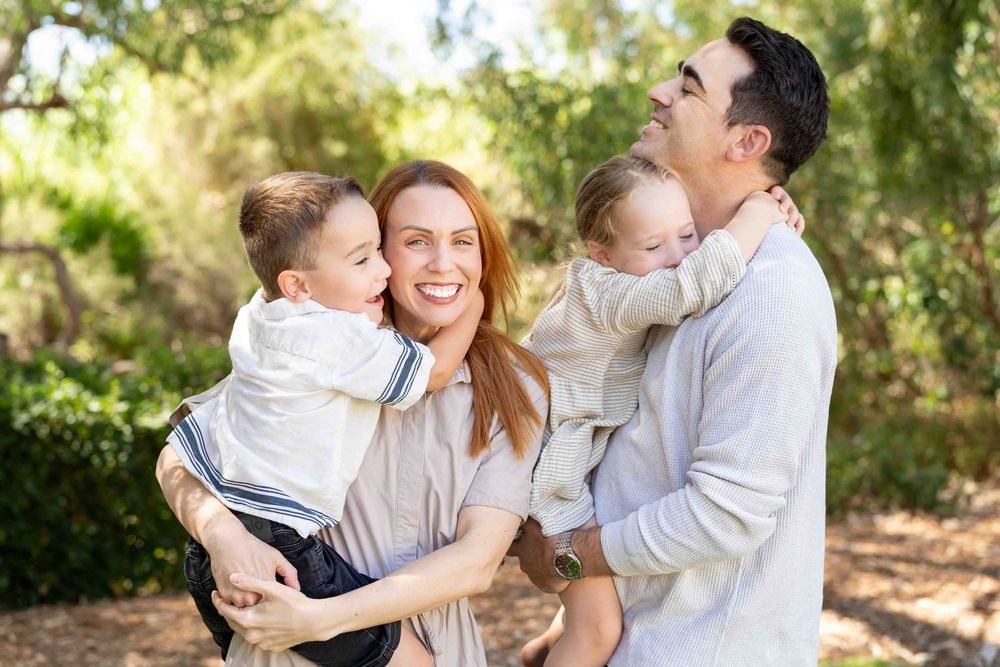 A family holding their children during an outdoor family photography session in Perth