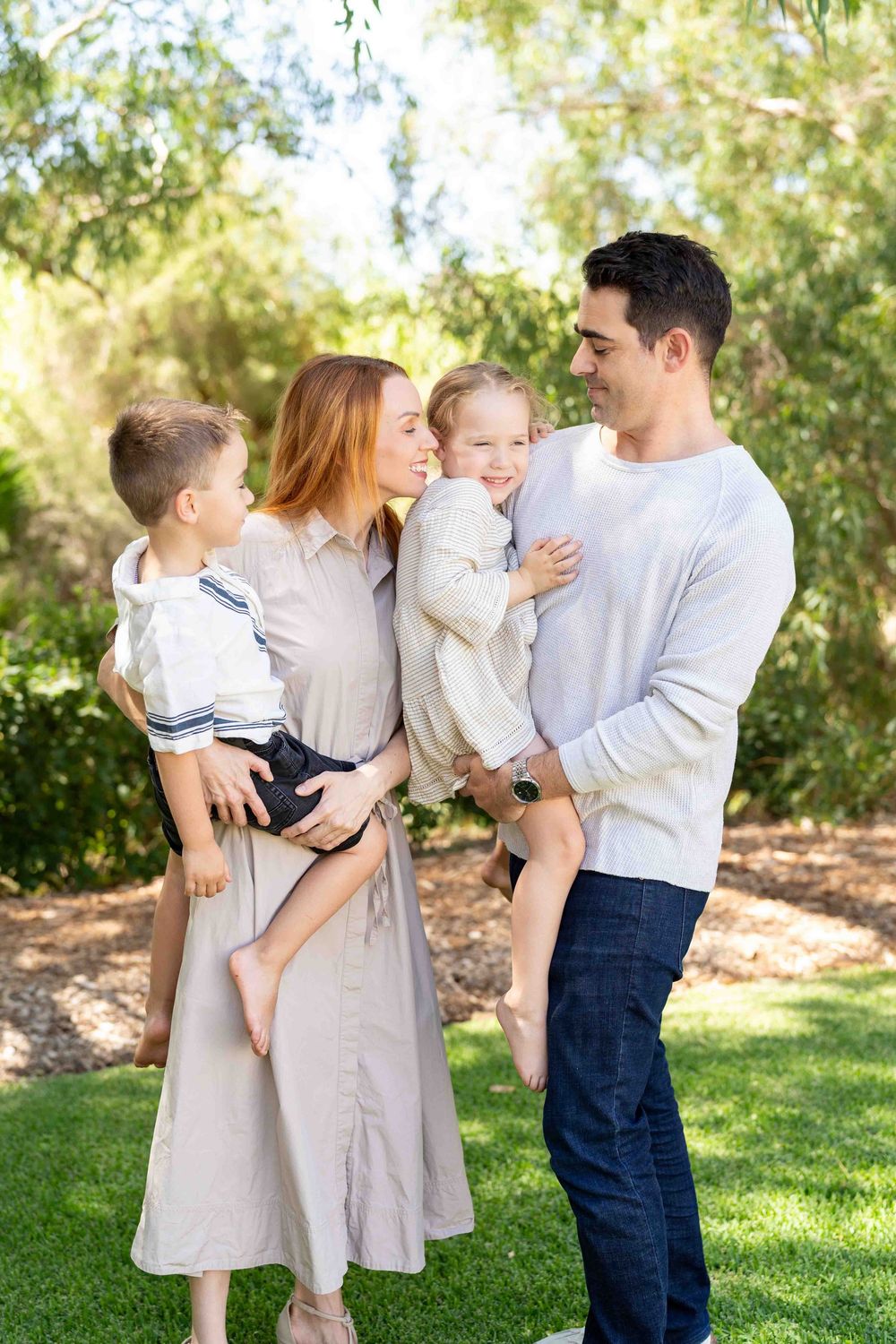 A family holding their children during an outdoor family photography session in Perth