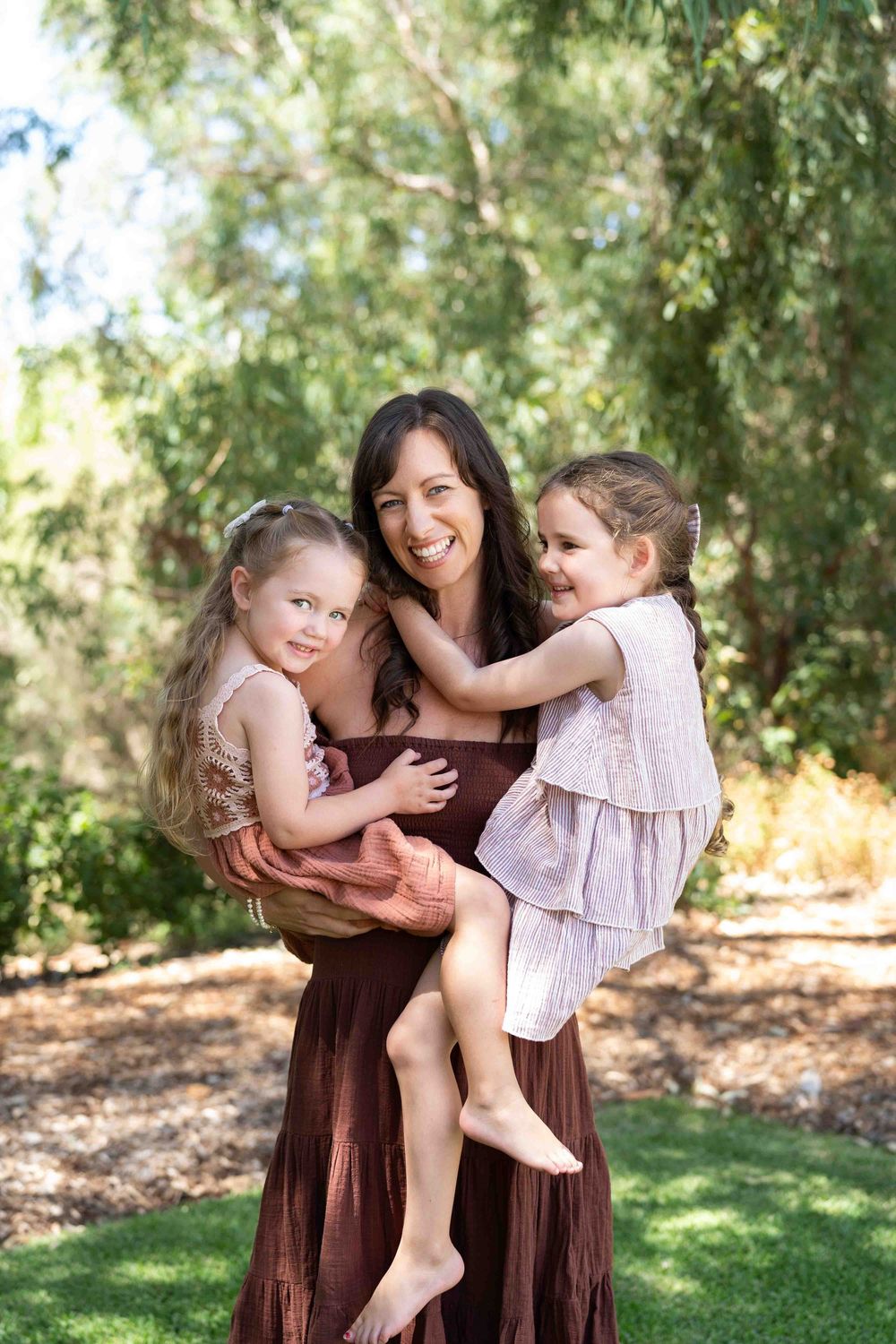 A mother holding her two children during an outdoor family photography session in Perth