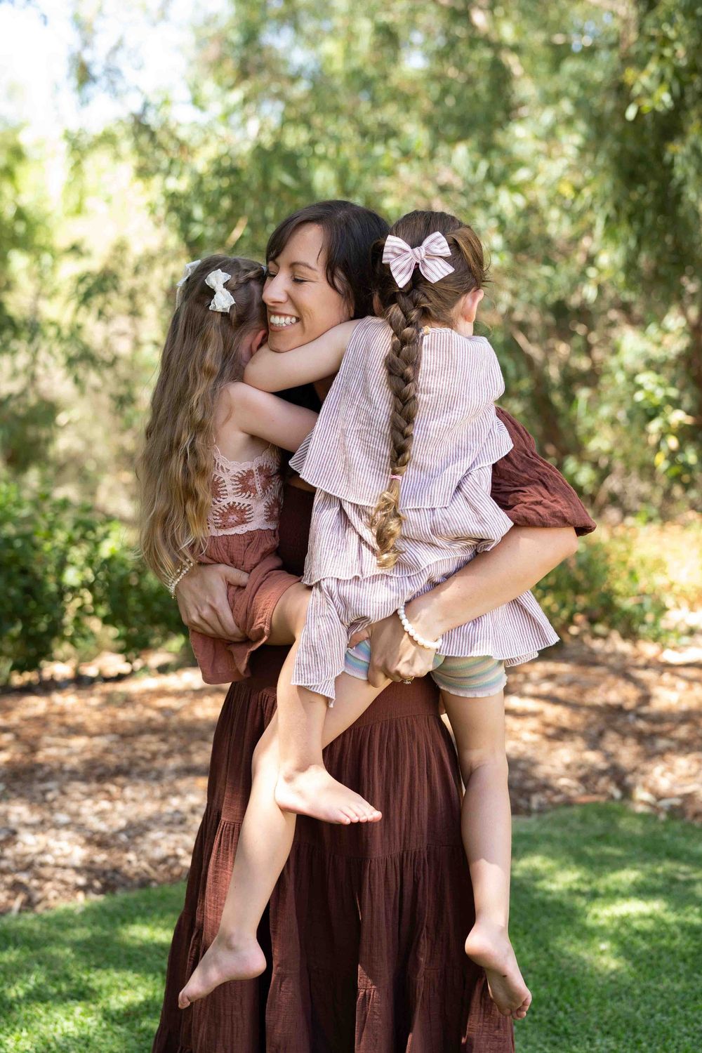 A mother holding her two children during an outdoor family photography session in Perth