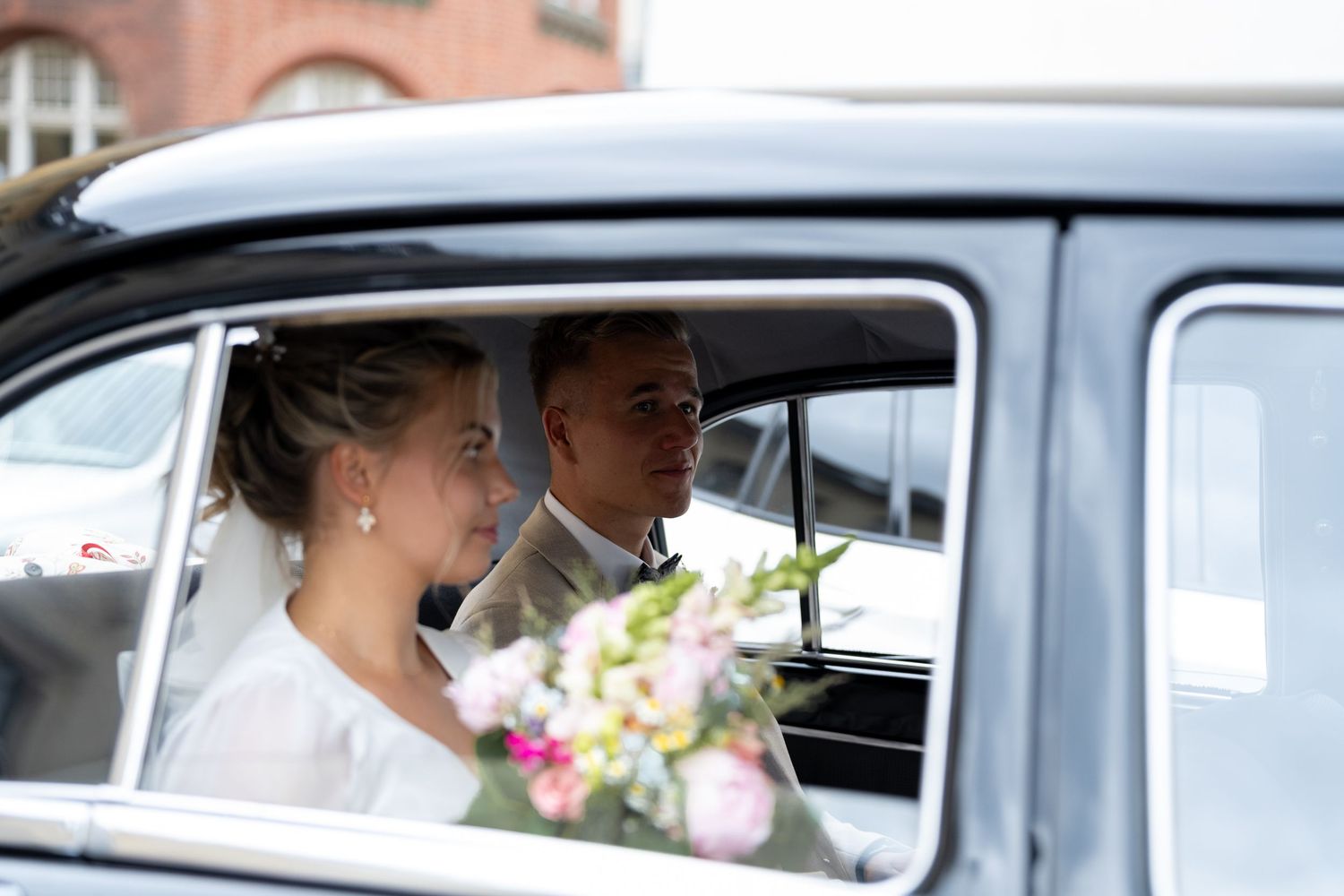 Brautpaar im Hochzeitsauto in Köpenick Berlin auf dem Weg zur Feier