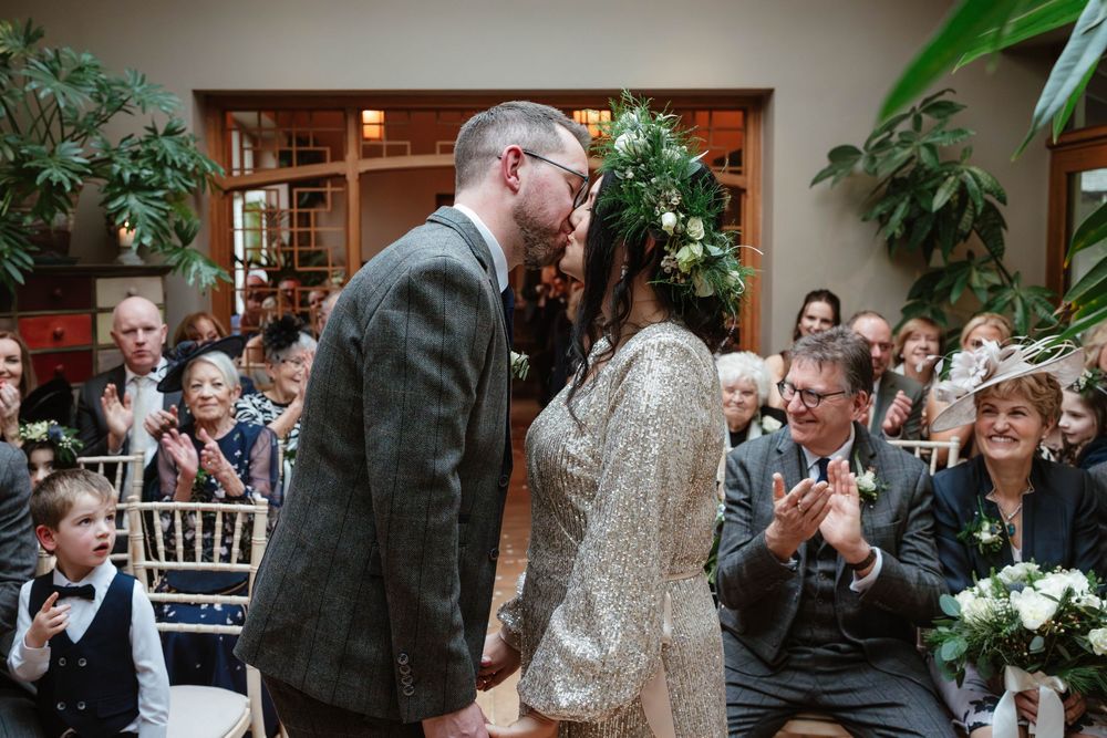 Matara Centre Wedding Photography Zara Davos Cotswolds Photographer Gloucestershire Stroud  bride and groom indoor ceremony first kiss