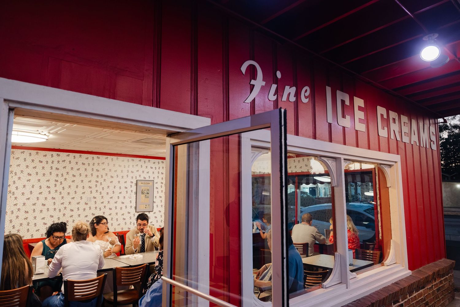 A vintage diner interior with red walls and white countertops features retro-style seating and classic American decor.
