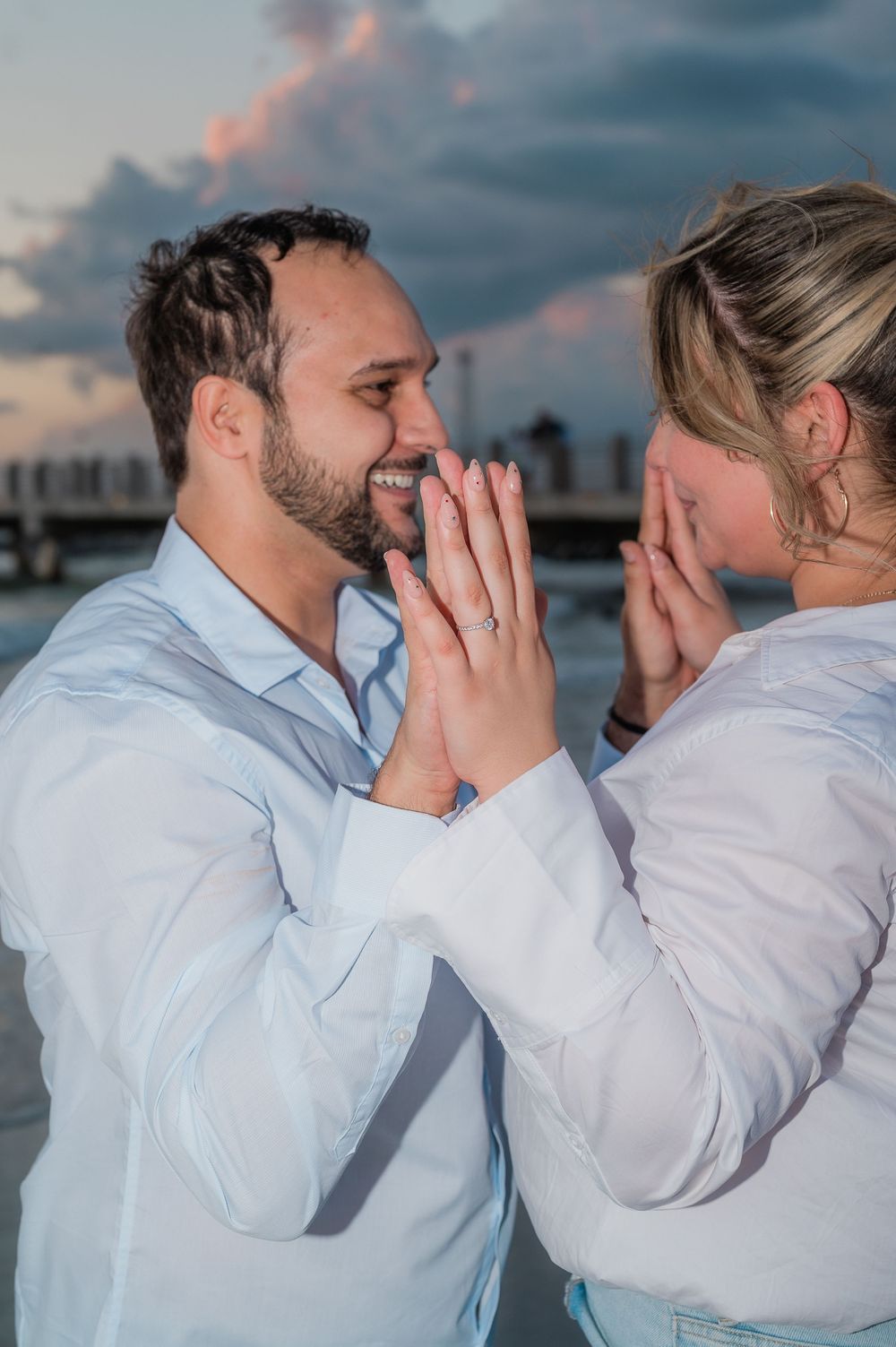 A romantic couple sharing an intimate moment at sunset by the ocean.