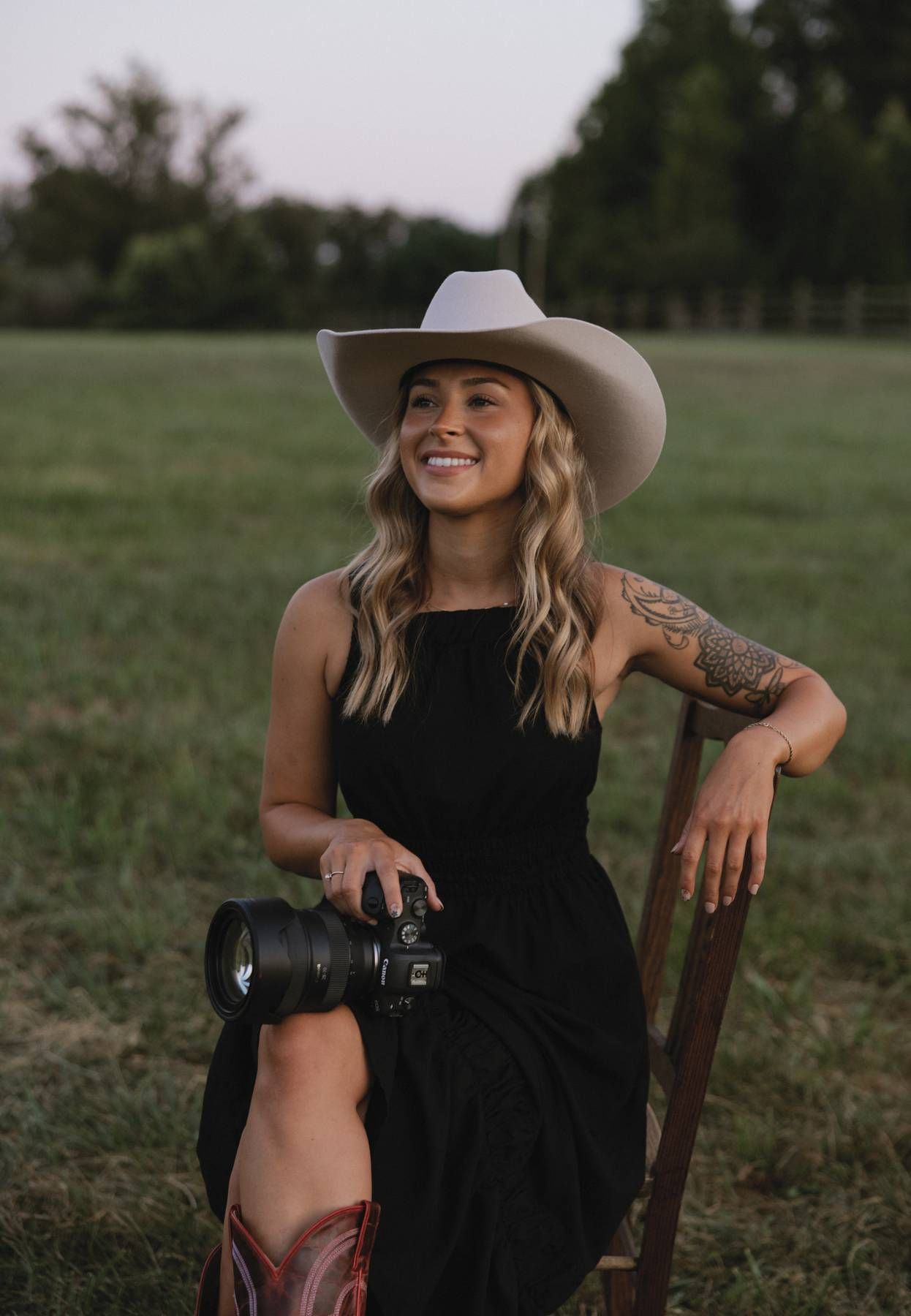 Outdoor photography session featuring camera equipment and western style accessories.