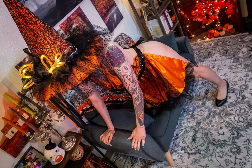 Person reclining on dark grey carpet with red Christmas lights and decorative elements visible in room.