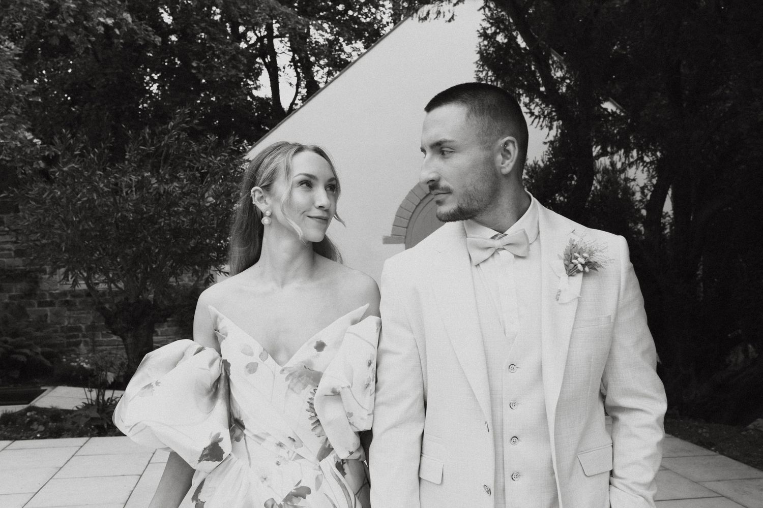 A romantic wedding photo series showing couples in white formal attire embracing in an outdoor garden setting.