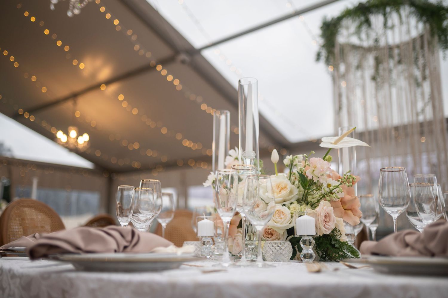Elegant wedding reception table settings with twinkling lights and floral centerpieces create a romantic ambiance.