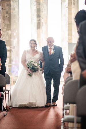 A series of candid wedding moments shows a couple sitting together at their reception in a historic venue with stone columns.