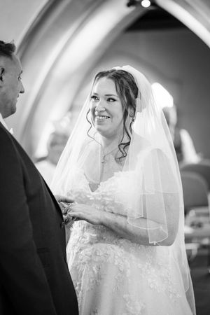 A candid series of black and white photos showing a bride in a lace wedding dress and veil during an emotional ceremony moment.