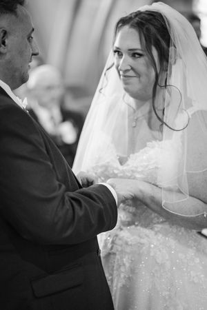 Close-up black and white shots of a bride in her wedding dress with lace details and veil.