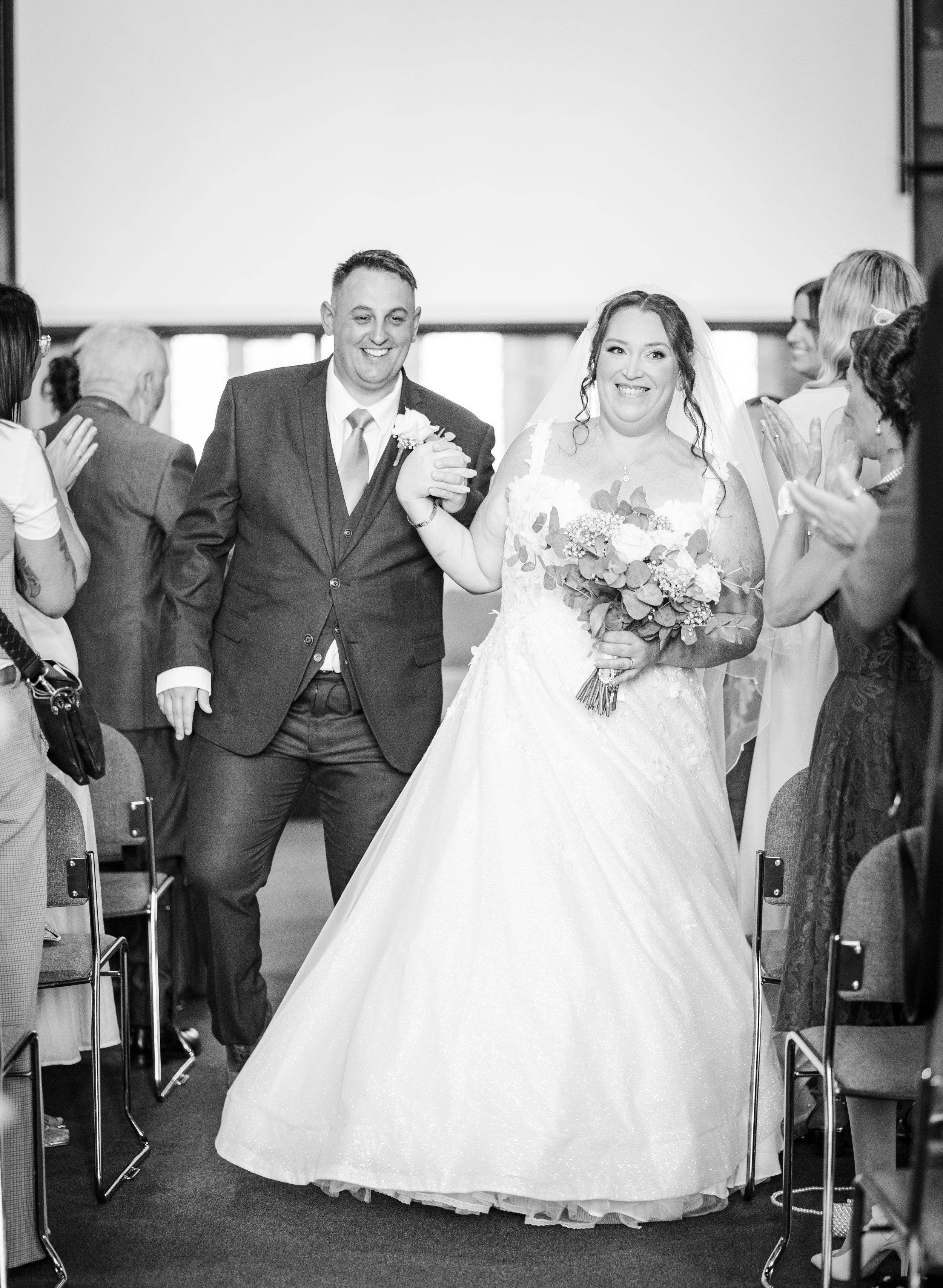 A series of joyful wedding party poses in black and white showing celebratory dancing moments at a reception.