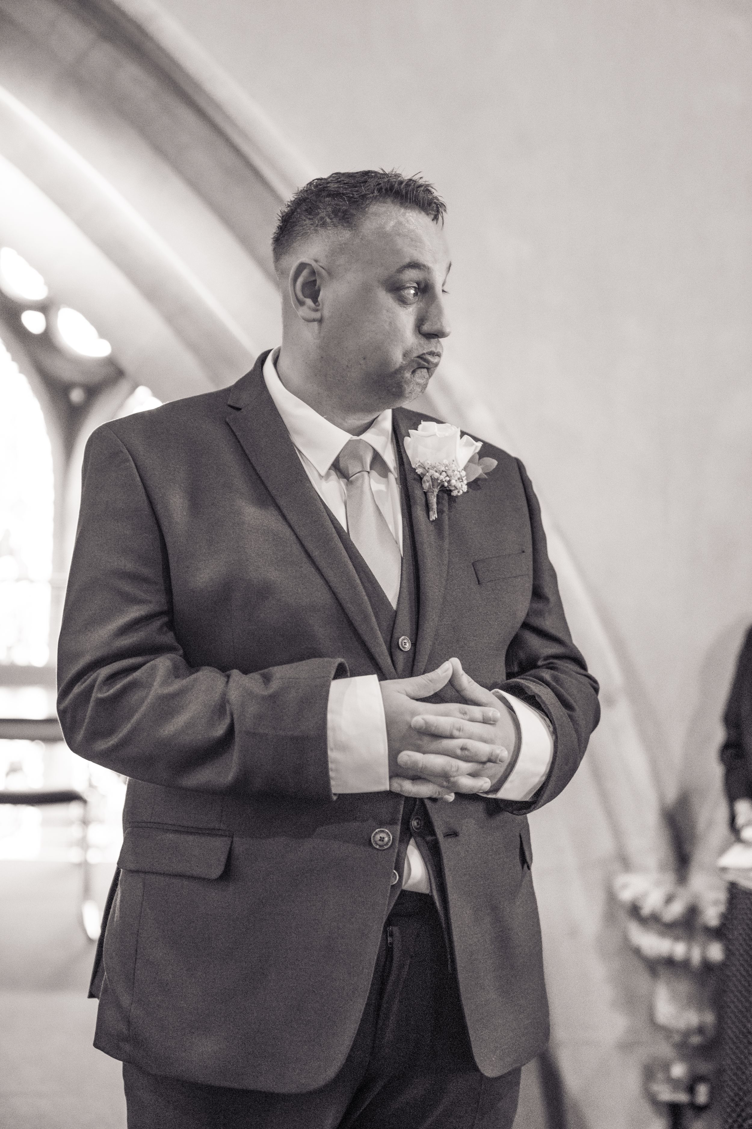 A person in a dark suit gestures while speaking in a sequence of candid black and white photographs.
