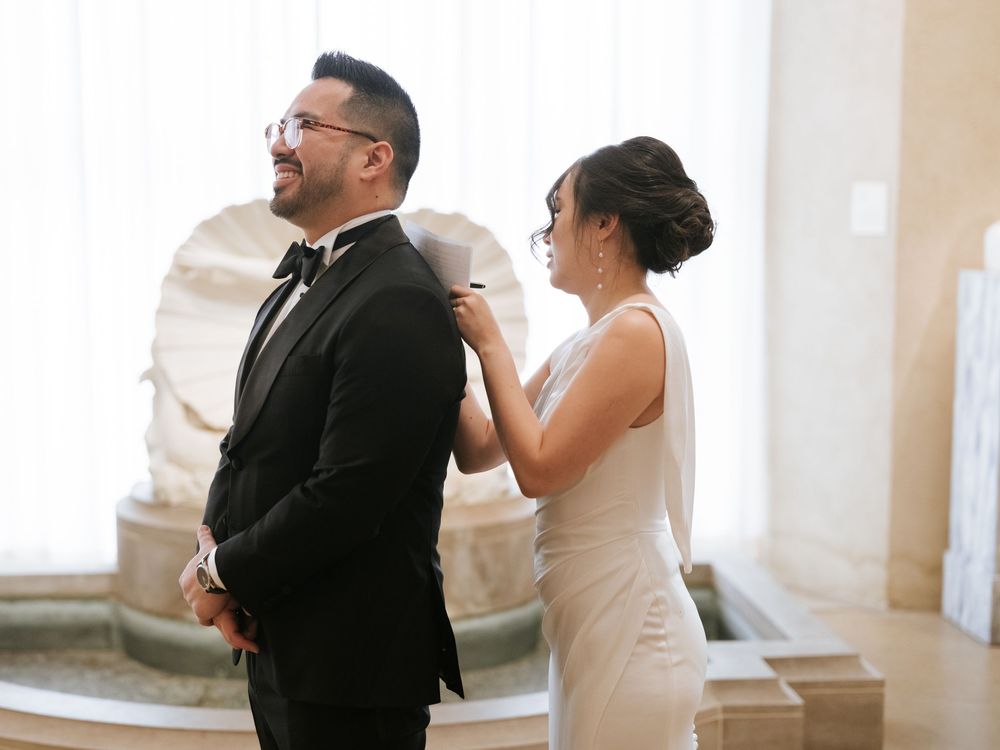 A couple in formal attire dance together during a romantic moment at an elegant indoor venue.