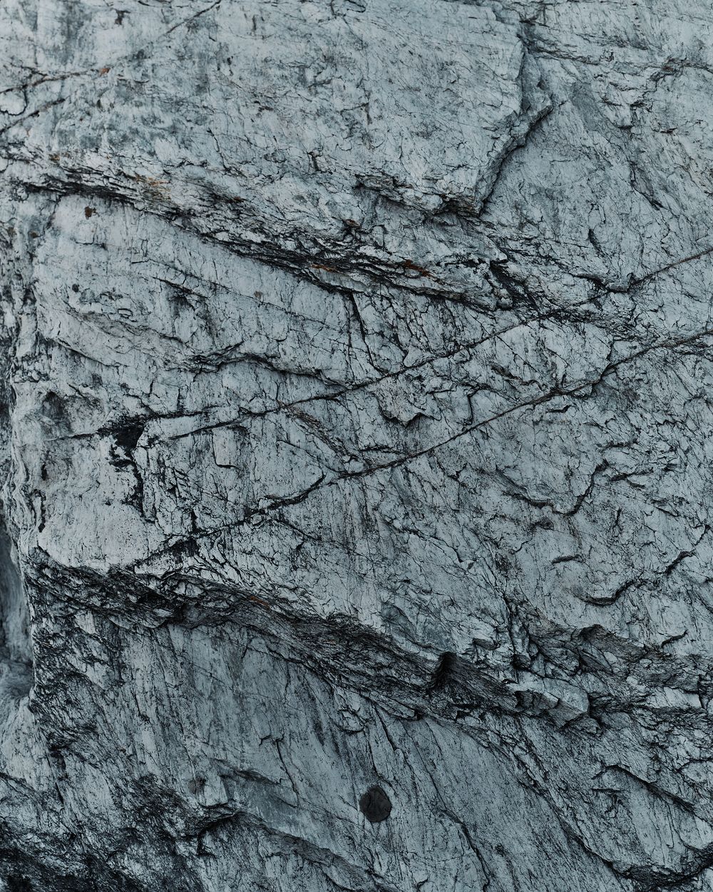 Close-up texture of rough gray limestone rock face with natural cracks and fissures.