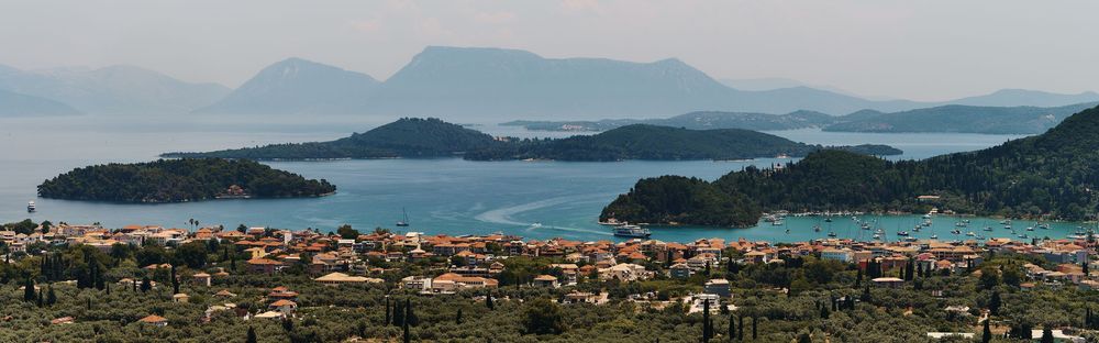 Panoramic view of coastal mountains and islands in Croatia with turquoise waters and seaside towns nestled along the shore.