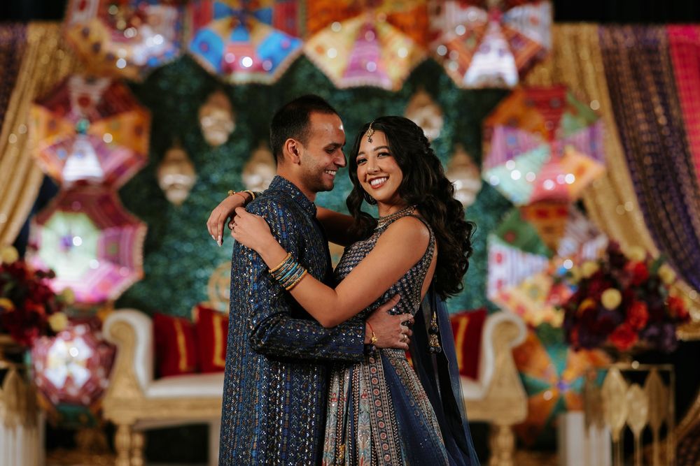 A couple shares romantic moments under colorful star-shaped lanterns during an evening celebration.