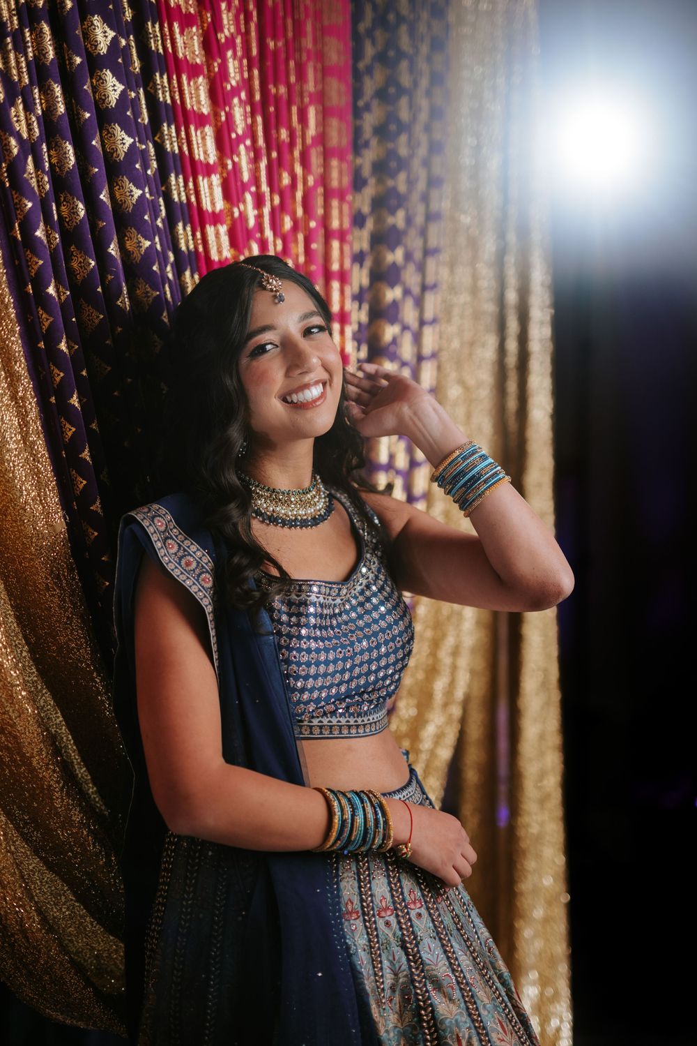 A traditional Indian celebration with decorative curtains and festive attire.