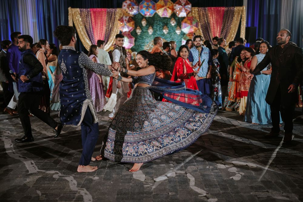 Dancers twirl on the dance floor at a colorful formal event with balloon decorations and festive lighting.