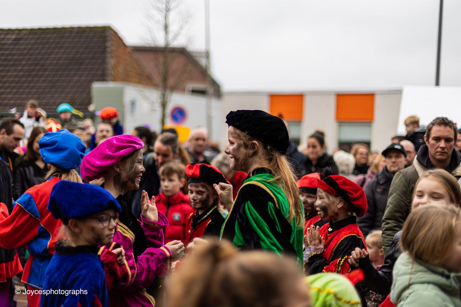 Colorful crowd of people celebrating at carnival parade with festive costumes and bright decorations.