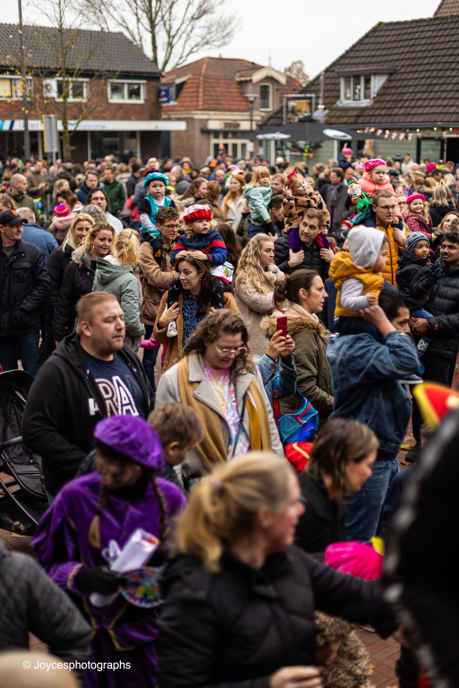 A large crowd of festival-goers celebrating outdoors in winter clothing, creating a lively party atmosphere.