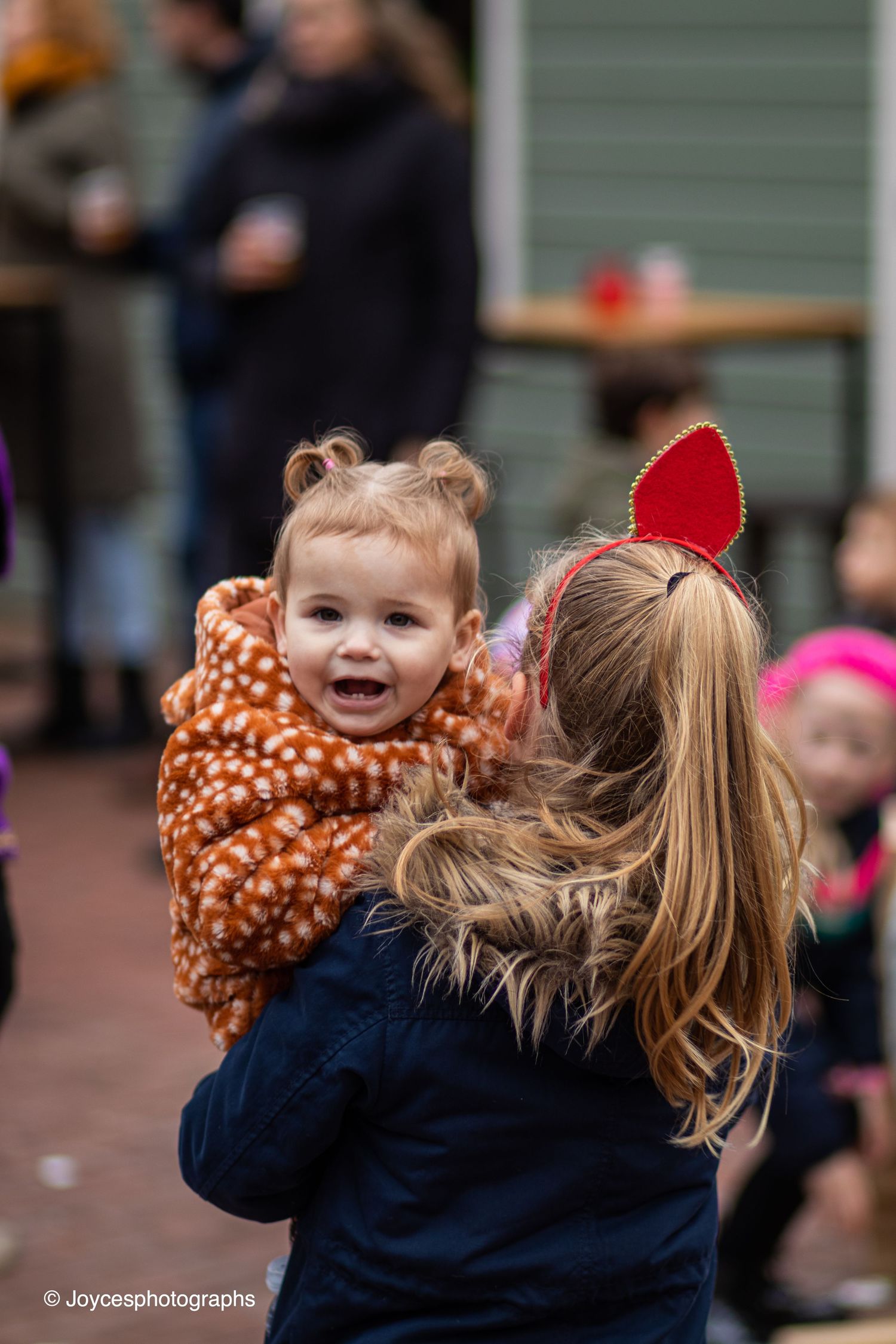 A sequence showing someone in a navy jacket and polka dot scarf looking up with excitement.
