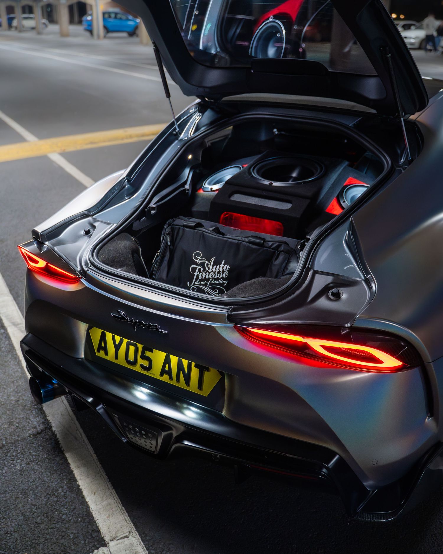 Close-up detail shots of a sleek black McLaren sports car showing taillights and rear design elements.