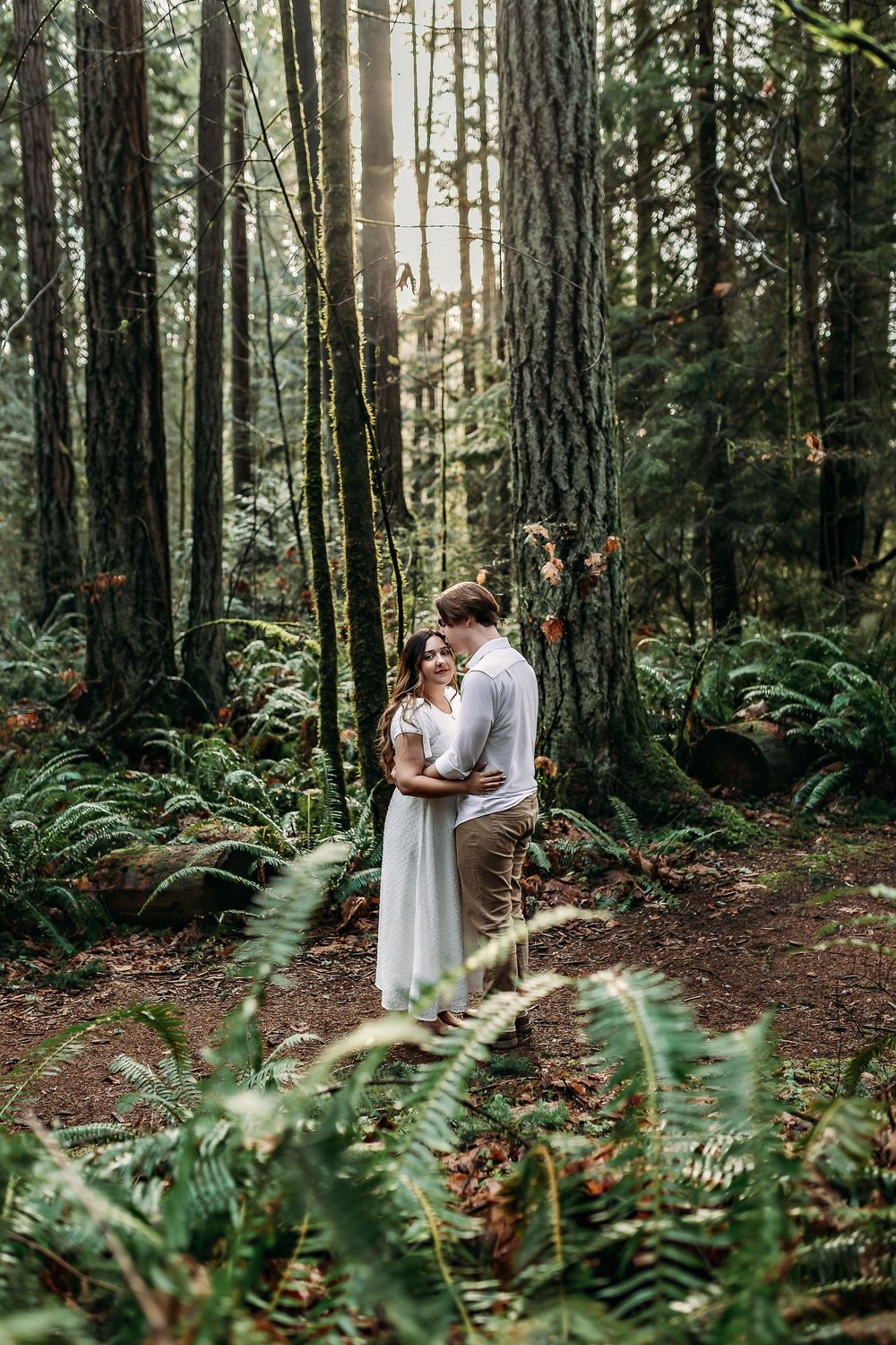 A romantic forest photoshoot among tall trees and ferns in a Pacific Northwest woodland setting.
