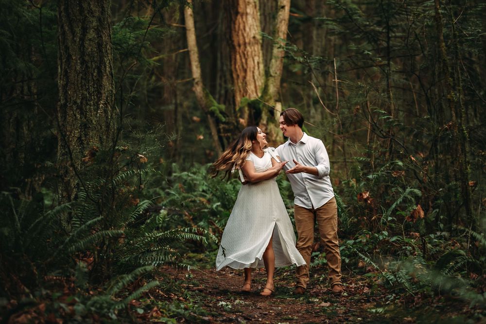 Intimate forest photography session with soft natural lighting filtering through tall trees.