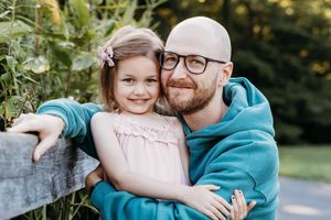 A sweet outdoor family photo session captured in a park during golden hour with gentle embraces and smiles.