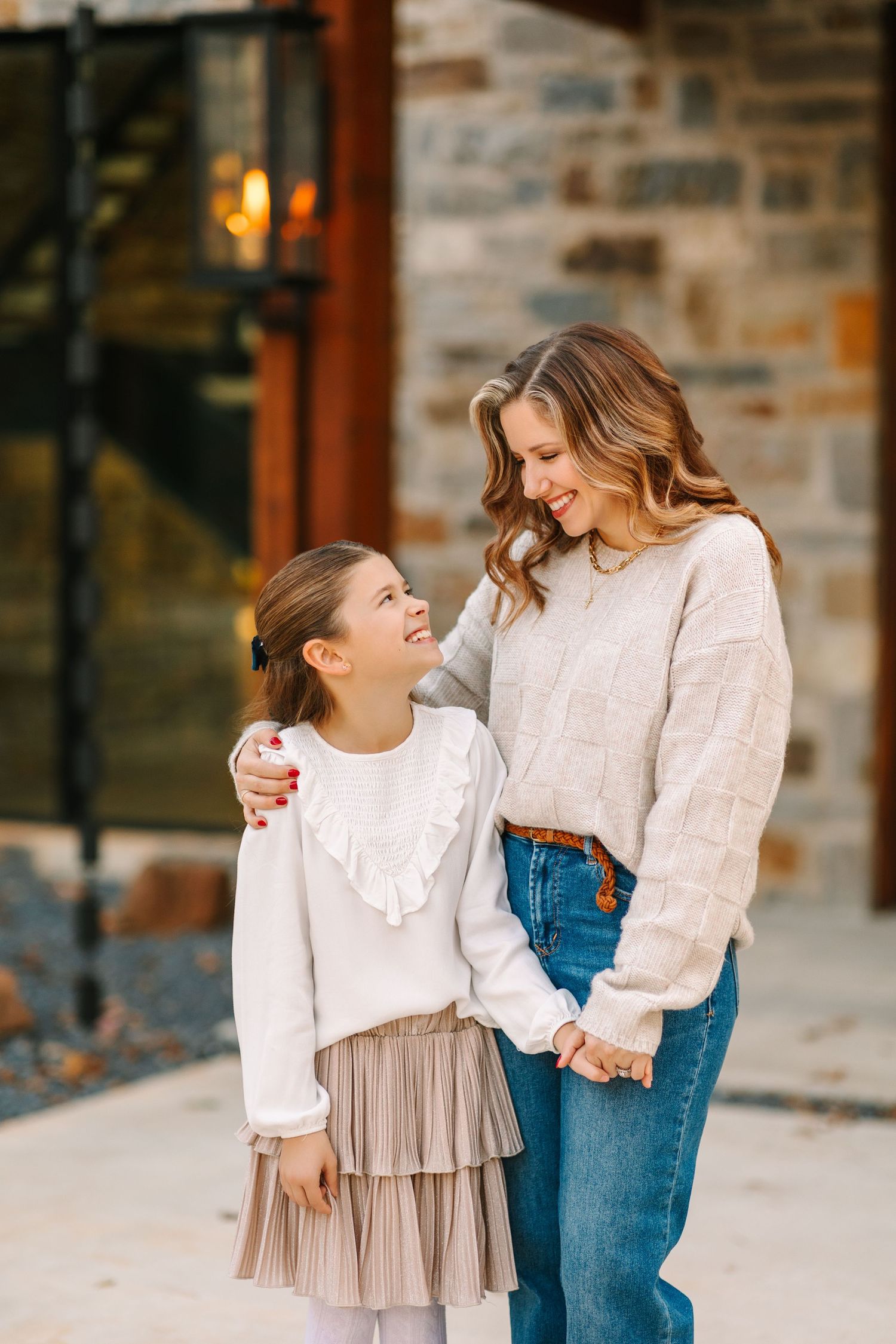 A heartwarming family moment captured in a sequence of candid poses against a stone wall background.