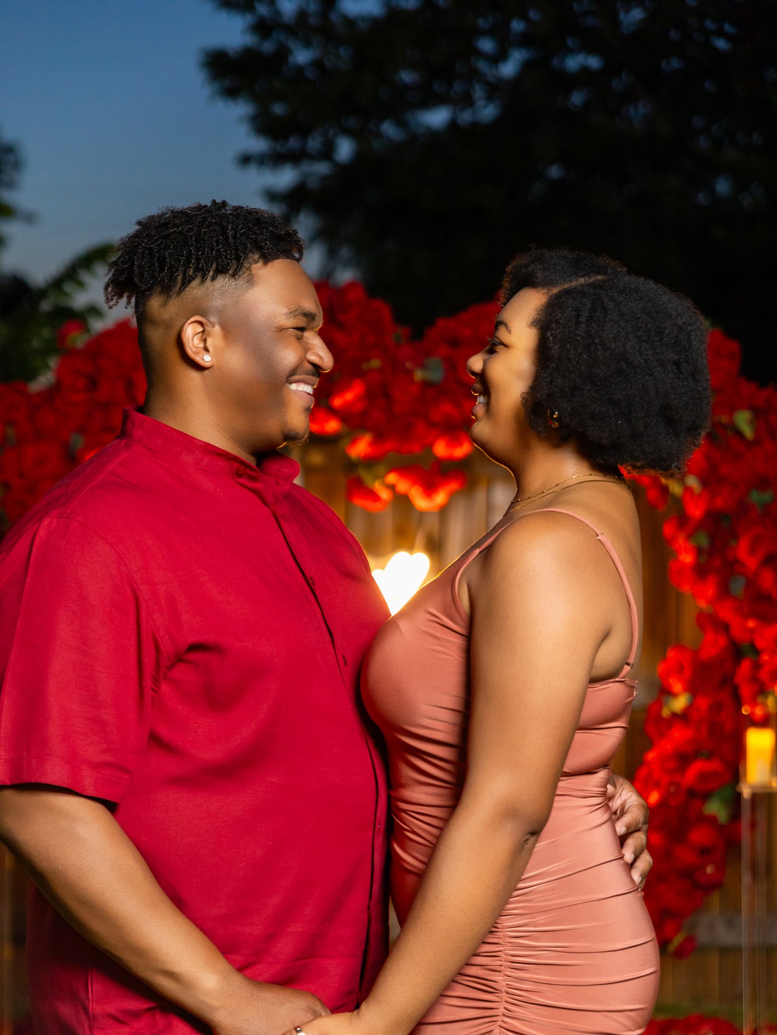 A couple shares a joyful moment together during an outdoor proposal photoshoot.